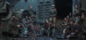Most members of the Maya Pei Brigade sit outside the wrecked Breon HOY-39 on Yavin 4.