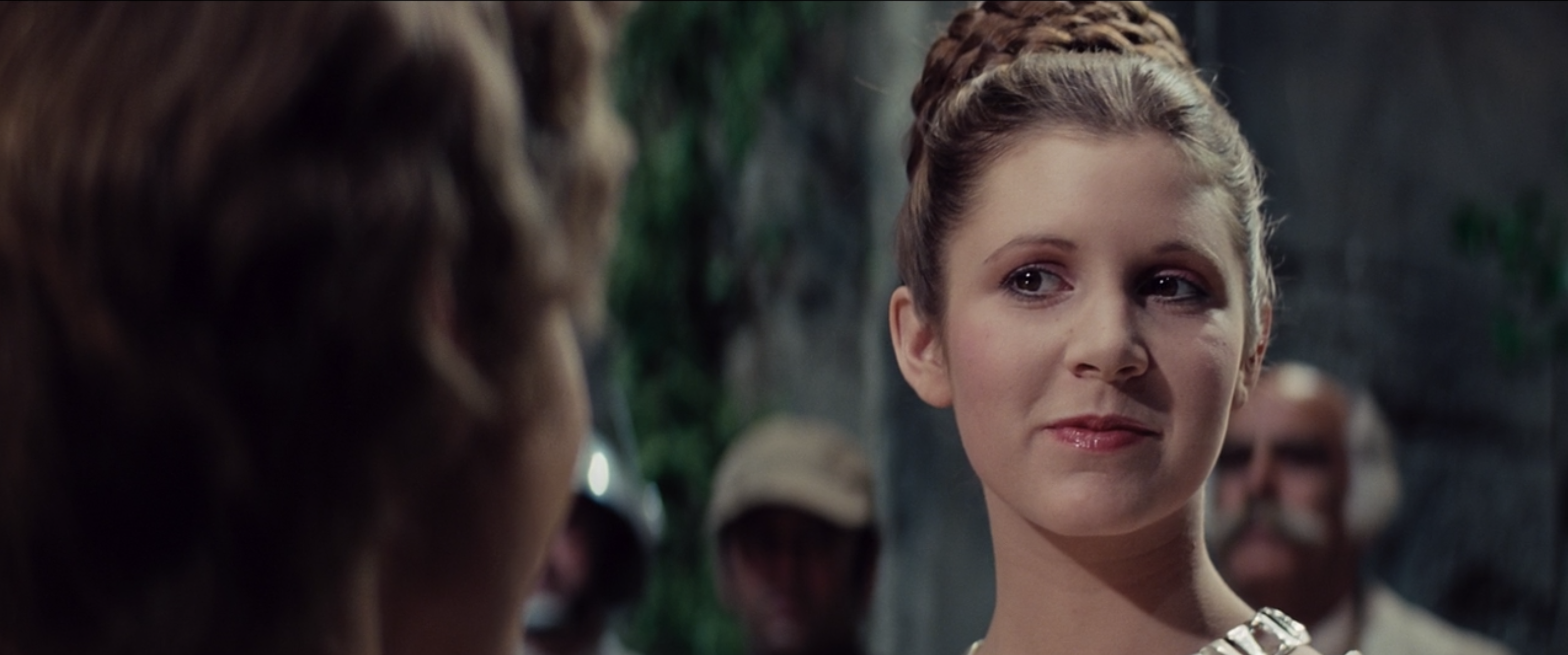 General Veertag looks on at Princess Leia Organa and Han Solo during the award ceremony.