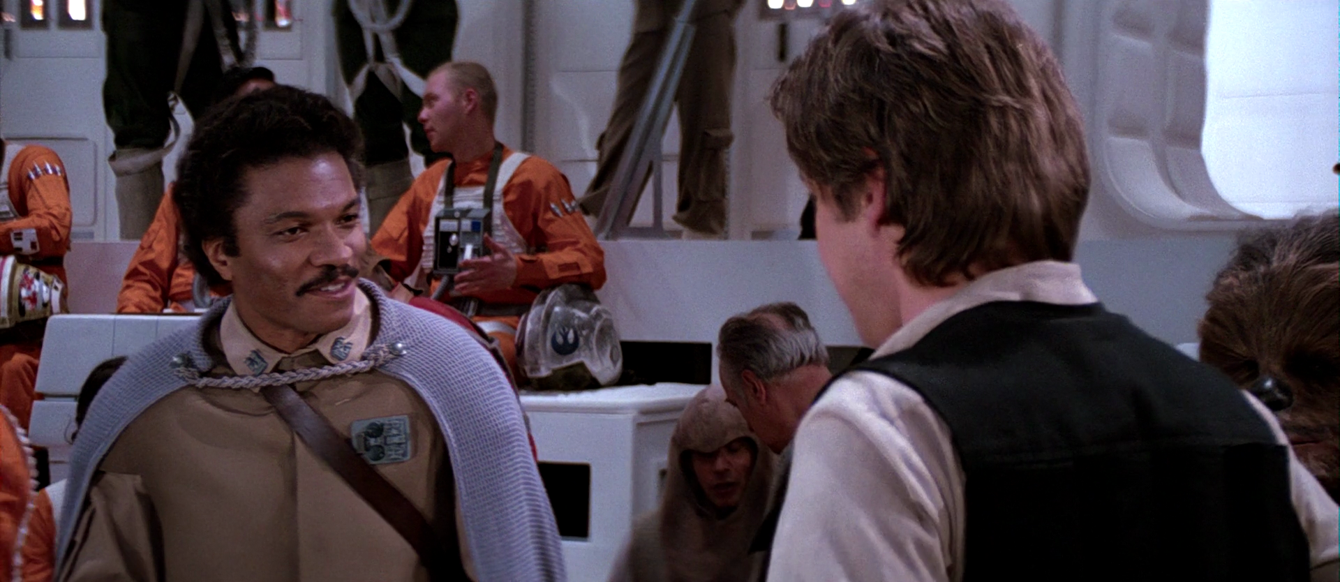 Newly appointed general, Lando Calrissian jokes with Han Solo before a rebel briefing aboard Home One.