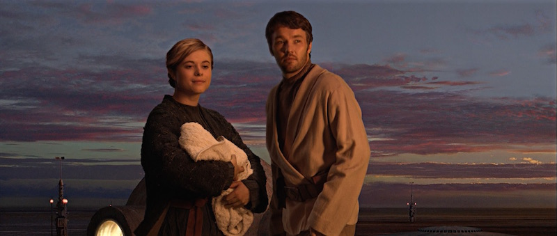 Beru and Owen Lars hold the infant Luke Skywalker and watch Tatooine's binary sunset.