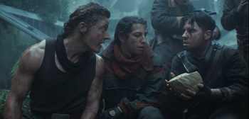 Rowd leans toward Bardi and Flu, the latter of whom is holding a cut open Yavin 4 melon.