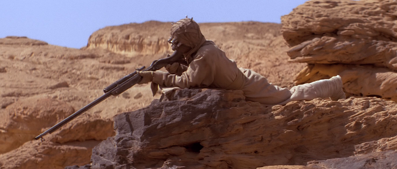 A Tusken Raider taking aim at podracers in the Boonta Eve Classic