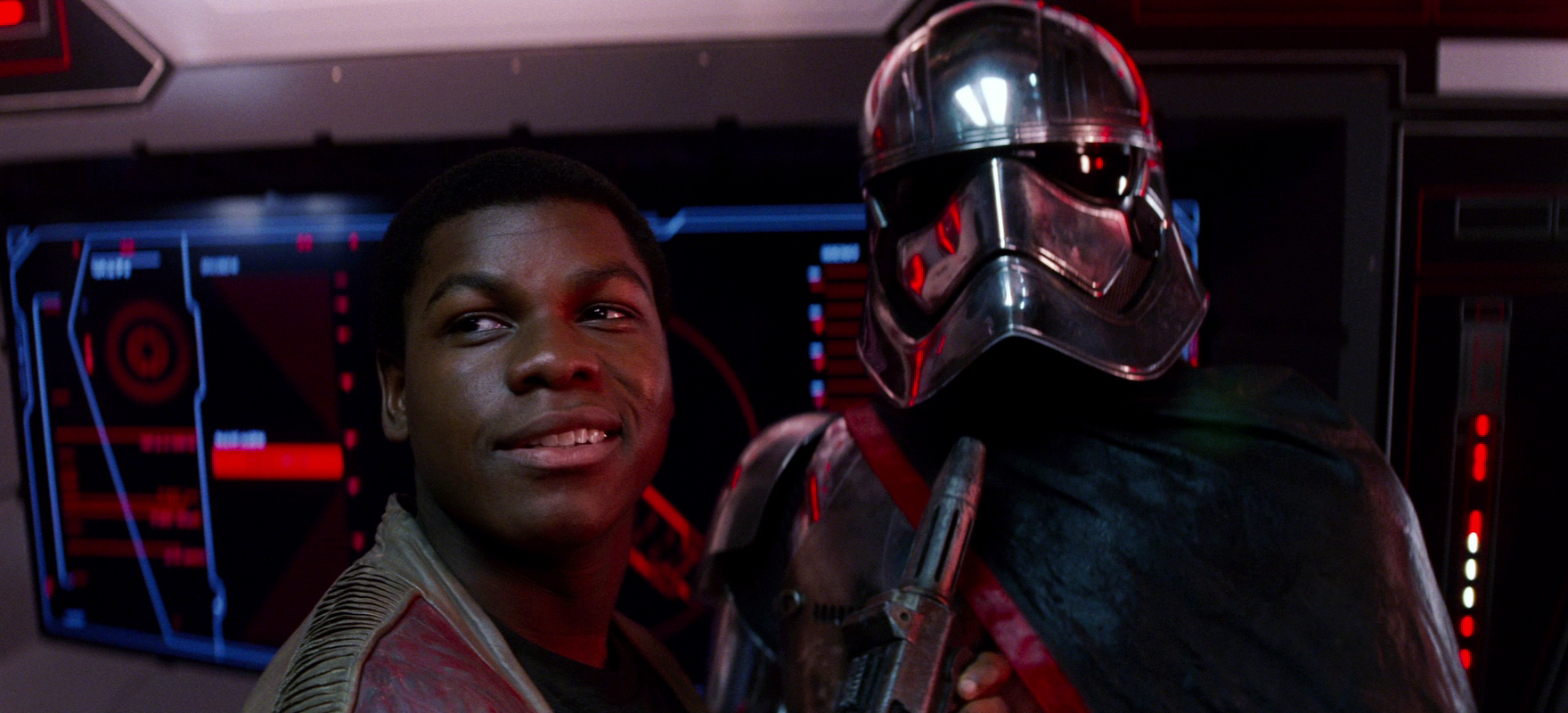 Finn holds Captain Phasma at the point of his blaster.