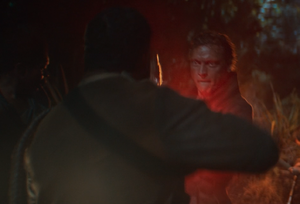 Red light washes over Rowd's face as he blasts Crab in the chest during the night on Yavin 4.