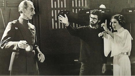 Director George Lucas (middle) instructs Peter Cushing and actress Carrie Fisher on the set of Star Wars.