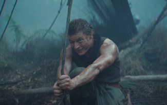 Rowd squints at a vine while kneeling down in order to measure how far his allies have turned the TIE Avenger on Yavin 4.