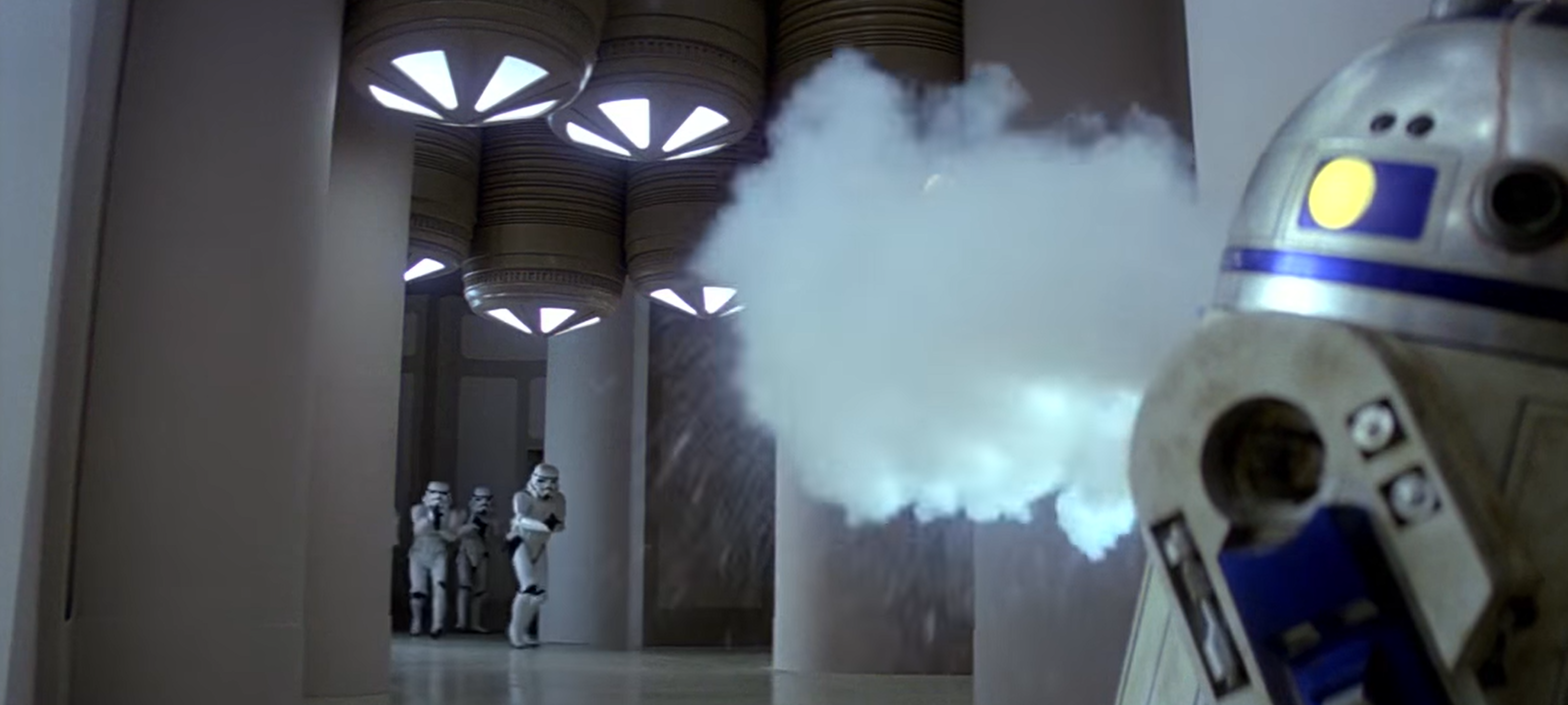 R2-D2 sprays smoke at incoming stormtroopers to cover his friend's escape