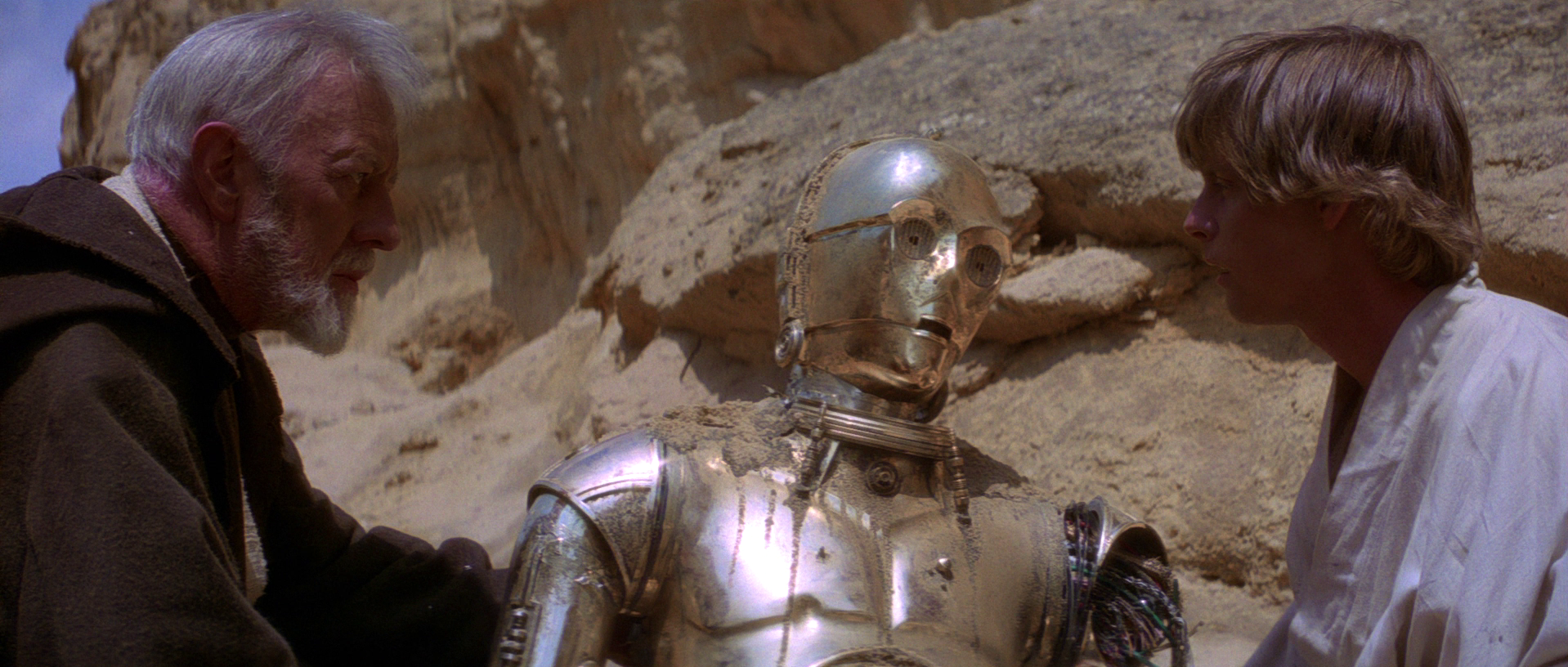 Obi-Wan Kenobi and Luke Skywalker help a damaged C-3PO after a Tusken Raider attack.