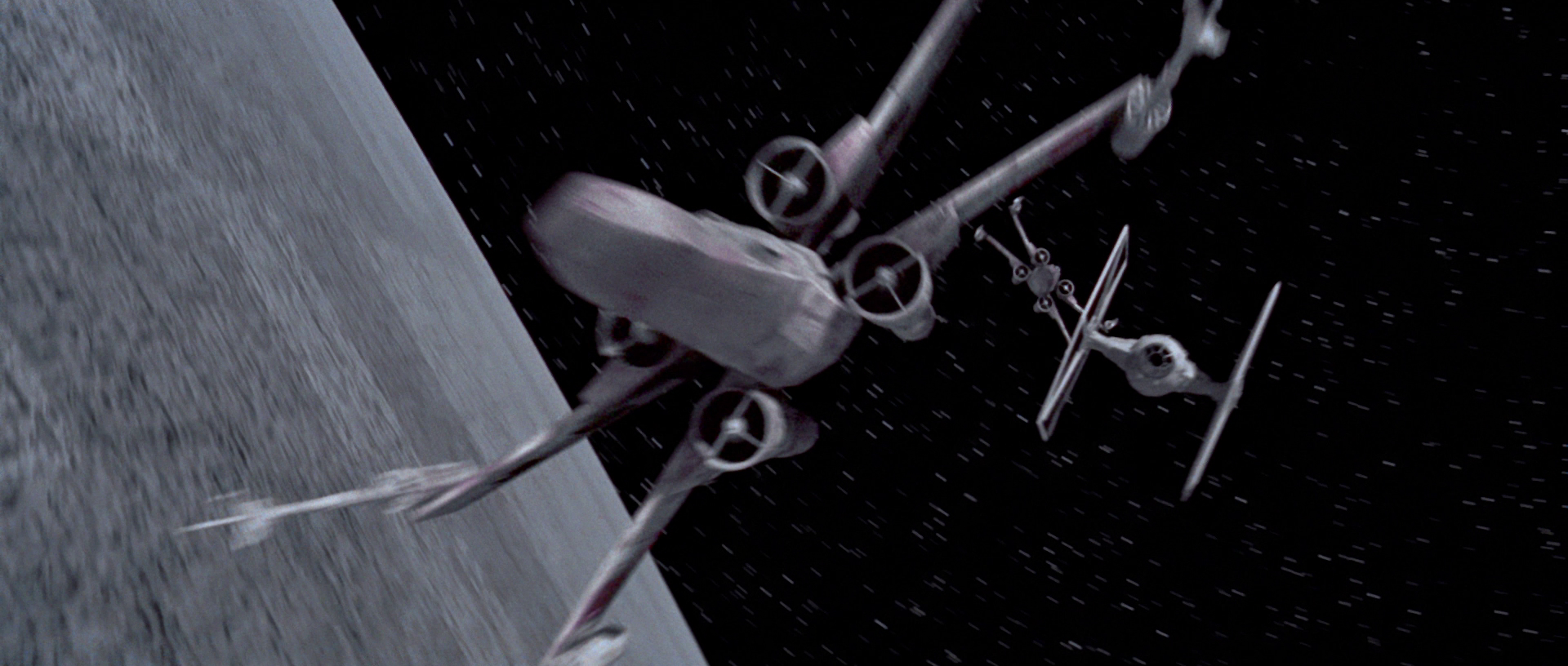 X-wings and TIEs engage in ship-to-ship combat above the surface of the Death Star