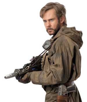 Beaumont Kin, a human with brown hair and a short beard, stands side-on to the viewer holding a blaster rifle and wearing brown combat fatigues with a blaster pistol in a holster.