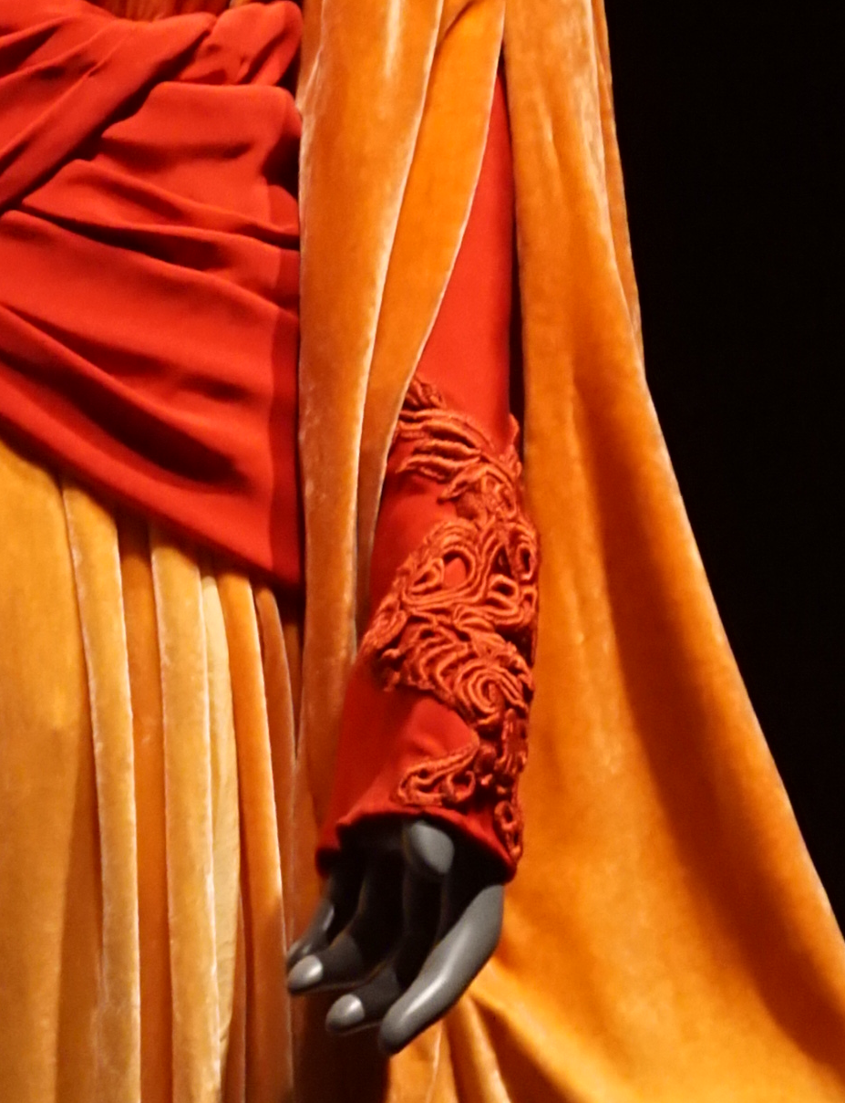 Detail of the sleeve shows red under-sleeve with guipure lace trim