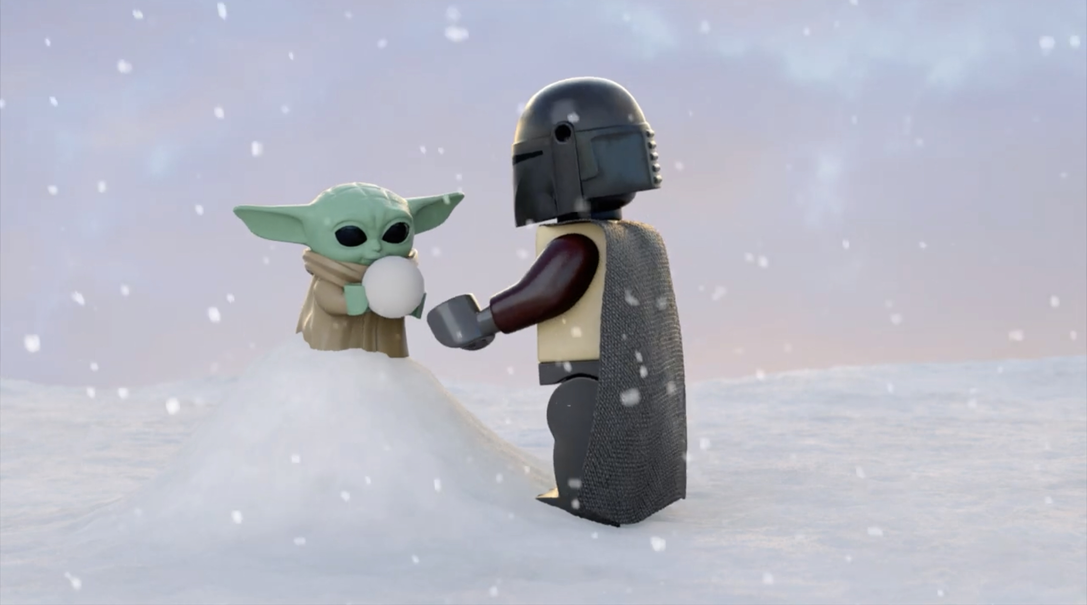 Din Djarin helps Grogu make a snowball.