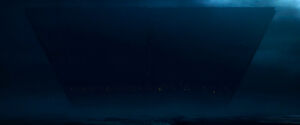 In a shadowy twilight, the boxy shape of the Sith Citadel looms over the horizon of Exegol.