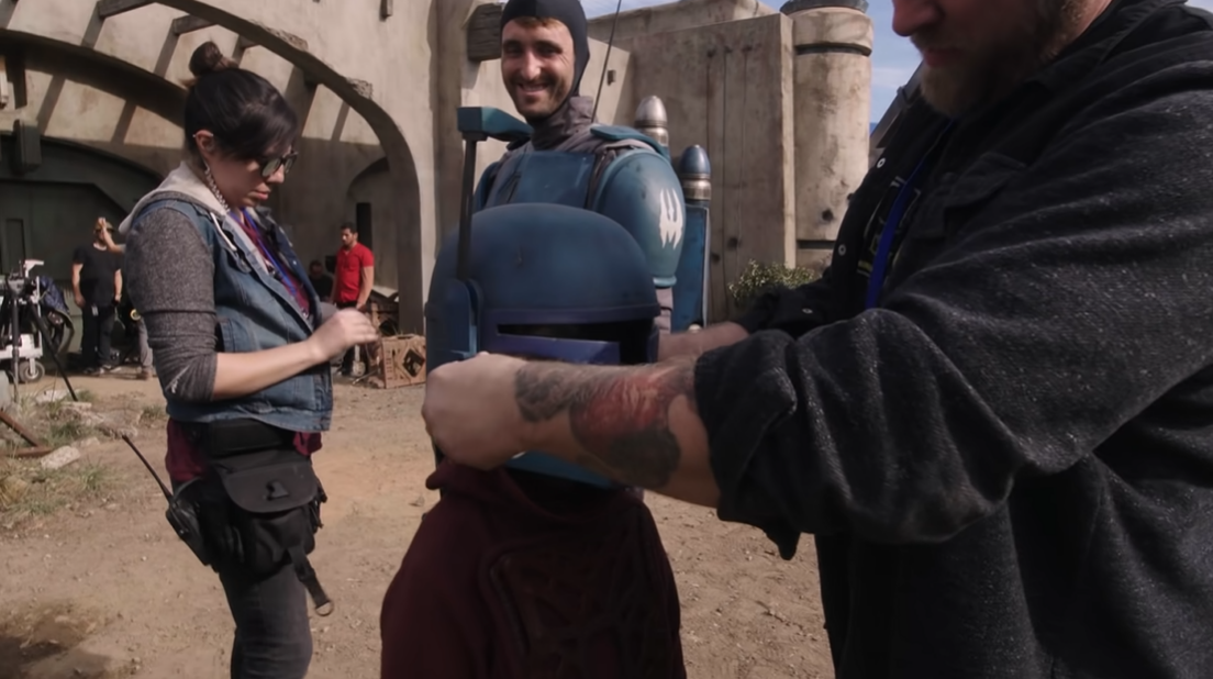 Aiden Bertola, the actor of young Din Djarin, tries on Brenden Wayne's costume helmet.