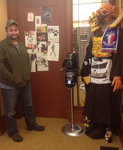 Dave Filoni posing by his Plo Koon costume at his Lucasfilm office in 2012.