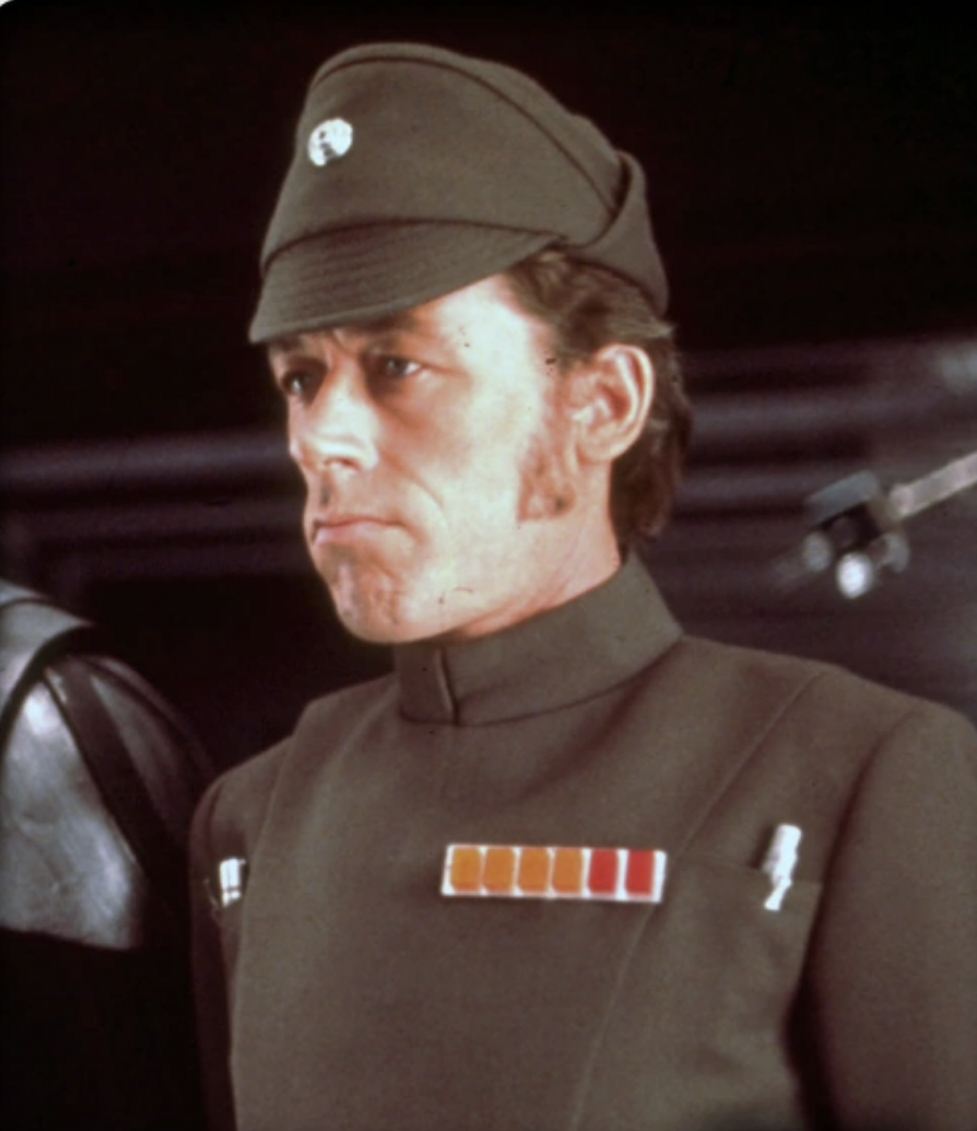 General Bast stands next to Vader aboard the Death Star