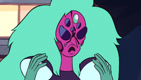 Alexandrite frowns, hands raised, as her face begins to crack apart.