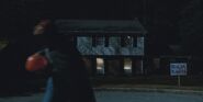 S2E02 A trick-or-treater walking in front of a house