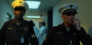 Two guards walking down the hallway.