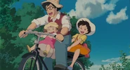 The father riding a tandom bike with his daughters.