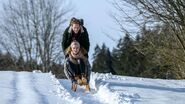 Maja und Florian machen auf ihrem Heimweg von der Almhütte eine Schlittenfahrt.