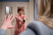 Susan bedroht Alicia mit einer Waffe.