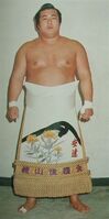Adachi poses with his kesho-mawashi (c. 1976)