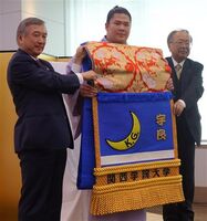 Ura gets presented with his kesho-mawashi (c. 2016)