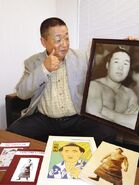 Komatsuyama's second son poses with his father's portrait (c. 2021)