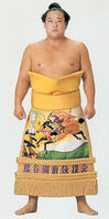 Kumao poses with his kesho-mawashi (c. 1992)