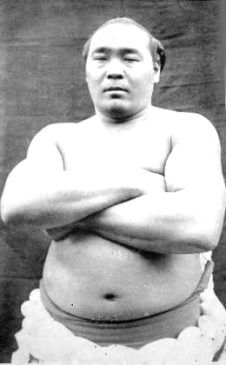 Ikezuki Goatazaemon next to a print of his hand, The sumo wrestler Ikezuki  Goatazaemon, with bare torso, depicted next to a full-size representation  of his hand. The text states that he came