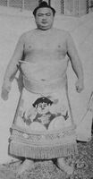 Hirokawa poses with his kesho-mawashi (c. 1967)