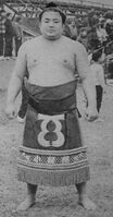 Toyokuni poses with his kesho-mawashi (c. 1967)