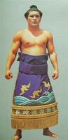 Yoshinotani poses with his kesho-mawashi (c. 1976)