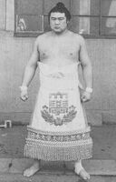 Onoumi poses with his kesho-mawashi (c. 1977)