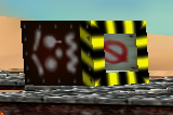 A Tox Box, that is lying on its side. The safe zone, where Mario goes unharmed can be seen on its right side.