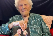 Caterham on her 115th birthday in 2024, holding her card from King Charles III