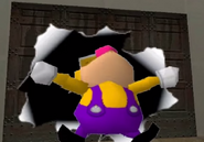 Wario bursts through the wall.