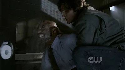 Sam exorcizes a demon after it kills Sheriff Dodd.