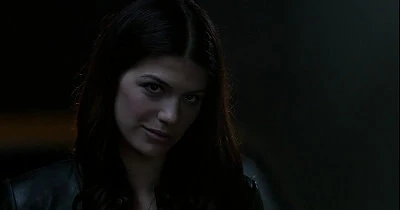 Ruby flashes a knowing smile as Sam listens to Dean's message.
