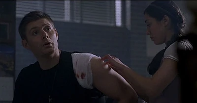 Nancy tends to Dean's gunshot wound while he shares the basics of dealing with demons.