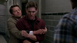 Castiel holds Demon Dean still and prevents him from advancing on Sam