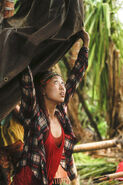 Mari places the tarp on the camp shelter.