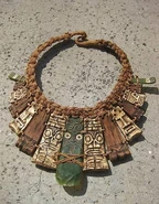Heroes vs. Villains A necklace of tan, brown and green tiki faces.