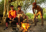 Ryan sitting by the campfire with Patrick and Devon.