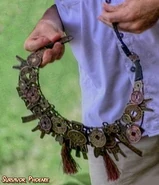 China A metallic necklace of symbols and thread.