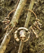 One World A necklace of wood, artifacts and a small painted skull.