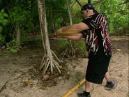 Billy tries to break a stick of bamboo.