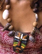 Borneo A small tiki with a colorful face with a necklace of shells.