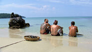 Scot, Jason, and Tai rest on the beach.